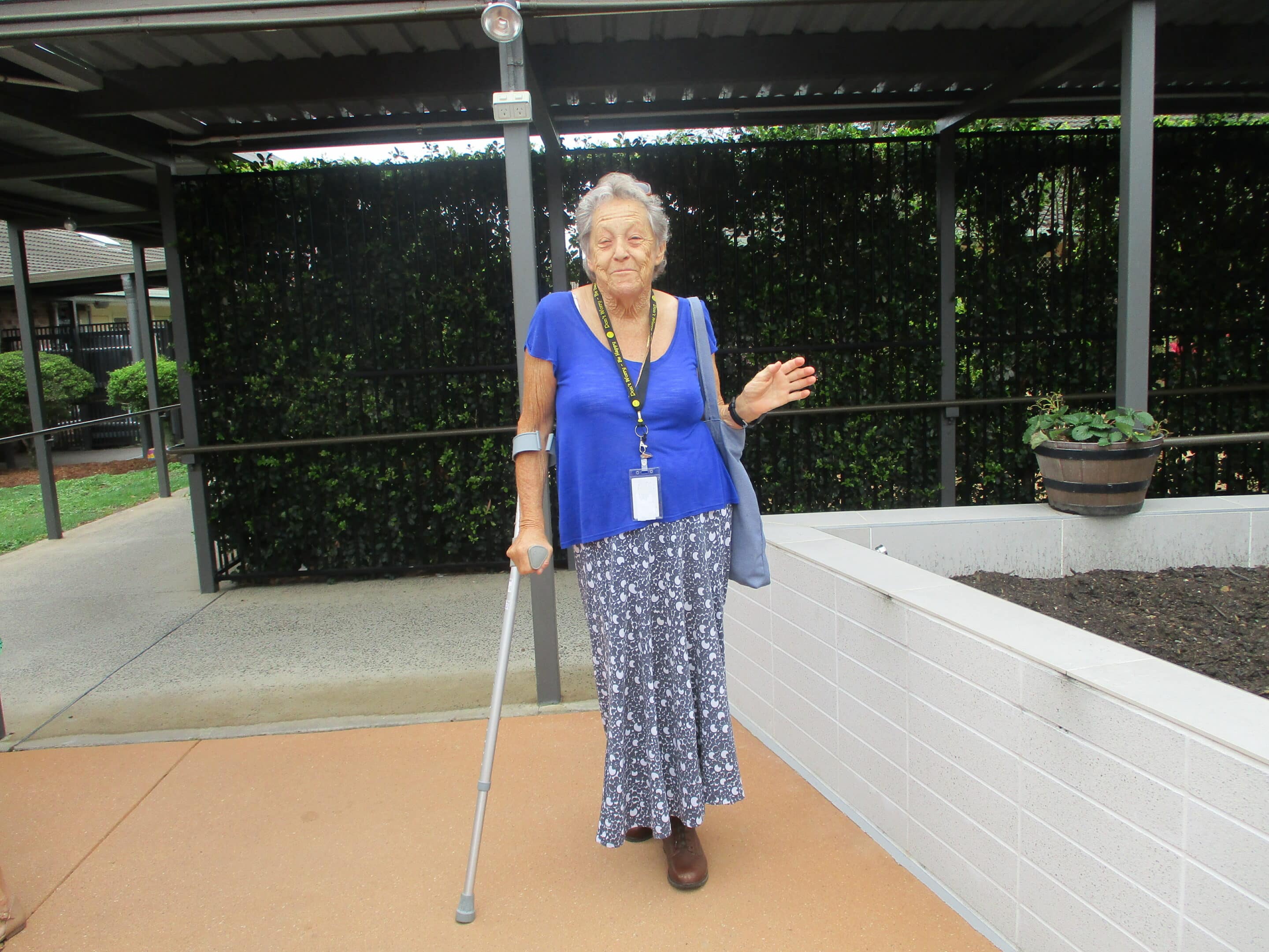 volunteer with one leg and walking stick in garden at Wommin Bay aged care centre